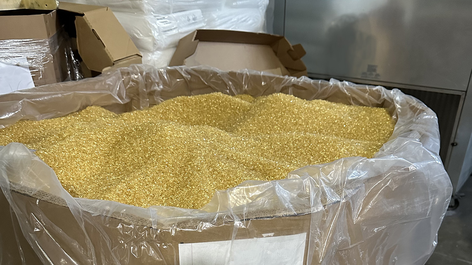 A gaylord of yellow polymer pellets.